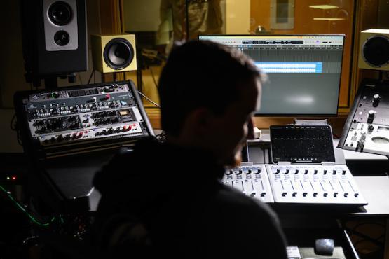 man in front of mixing and mastering tools