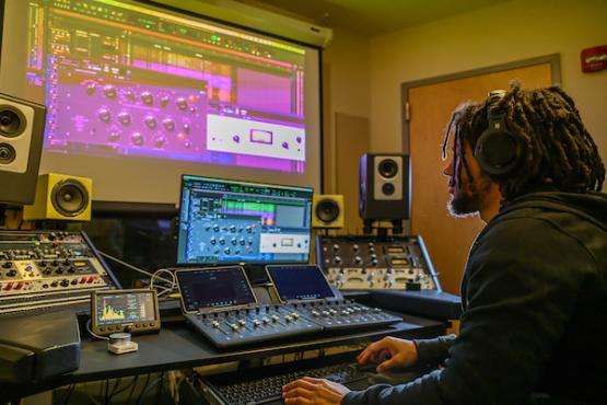 man with headphones using mixing and master tools in the studio