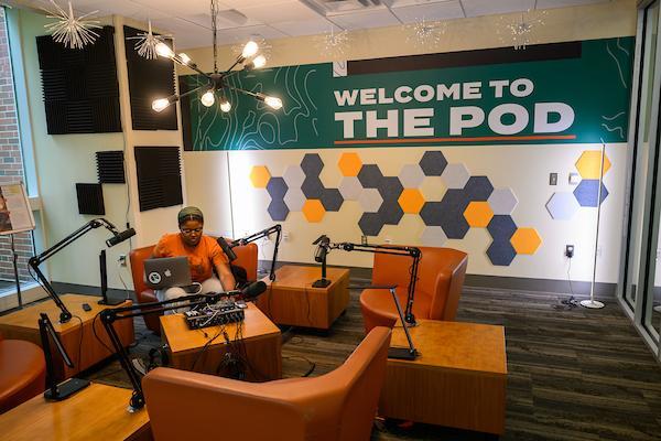 student in the podcasting studio, "Welcome to the Pod"