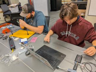 Ethan Feidtkou, ITS Cybersecurity major, works with a low end upconverter to feed the received signal to a portable software defined radio.