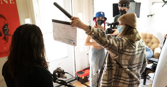 Students filming a movie inside of an apartment