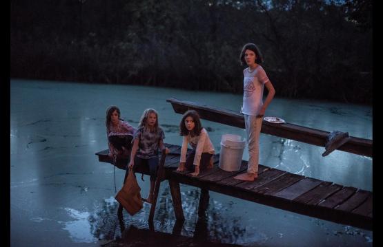 image of four young girls on a dock over a pond