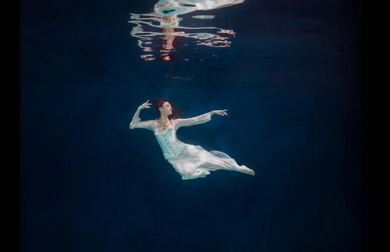 image of a woman posing underwater in a white dress