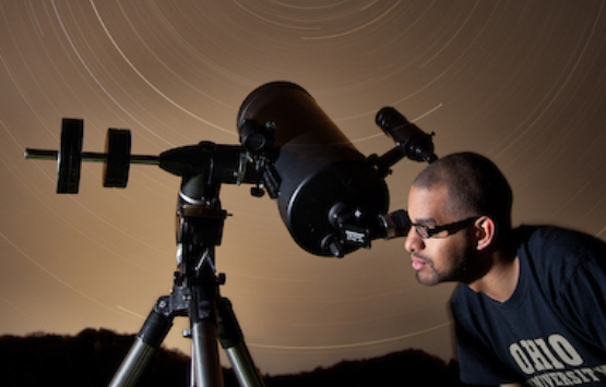 A student looks into a telescope