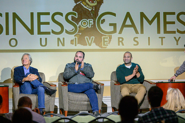 A group of people onstage participating in a panel discussion