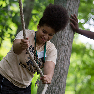 Student grabs a rope on the ropes course