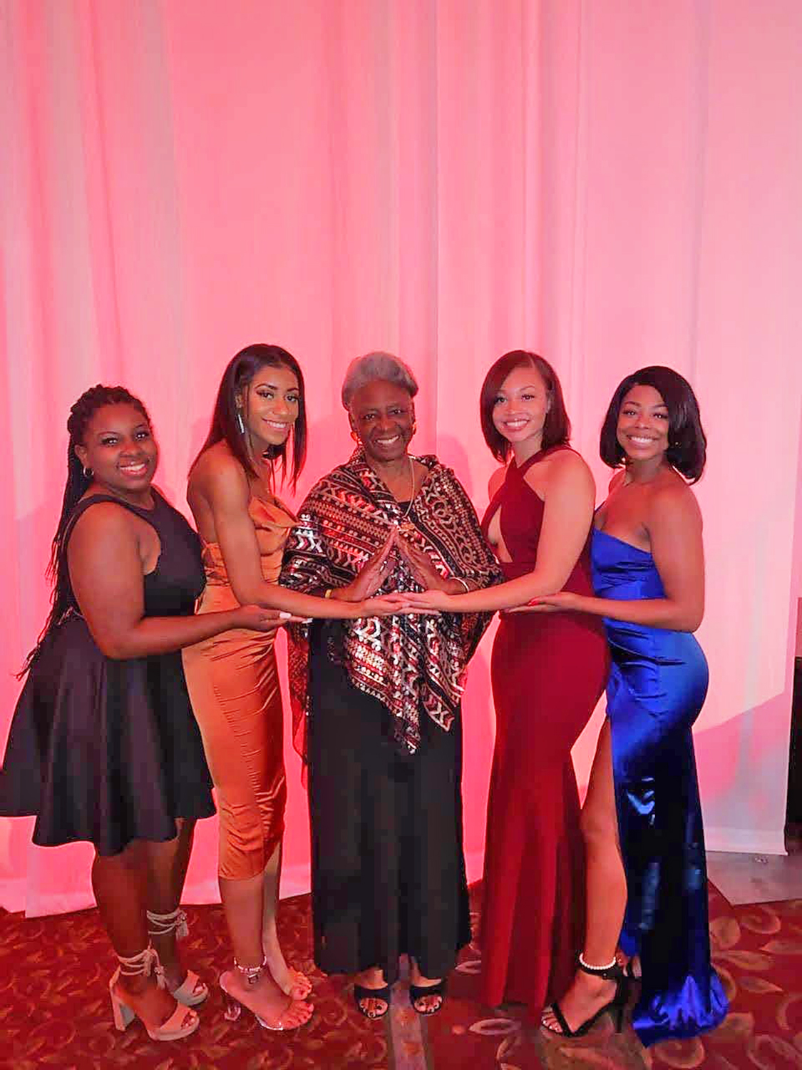 Living Legends Award Winner Connie Lawson Davis standing with her Delta Sigma Theta Sorority sisters throwing what they know