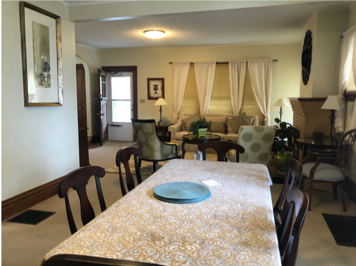 Open interior with living room and dining room, with traditional furniture and beige carpet