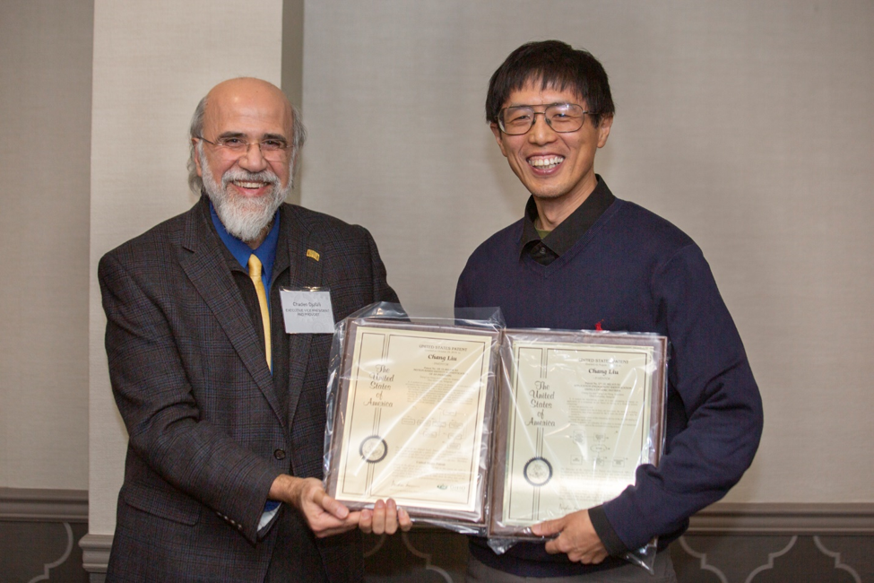 EVPP Chaden Djalali presents patent plaques to faculty inventor Chang Liu