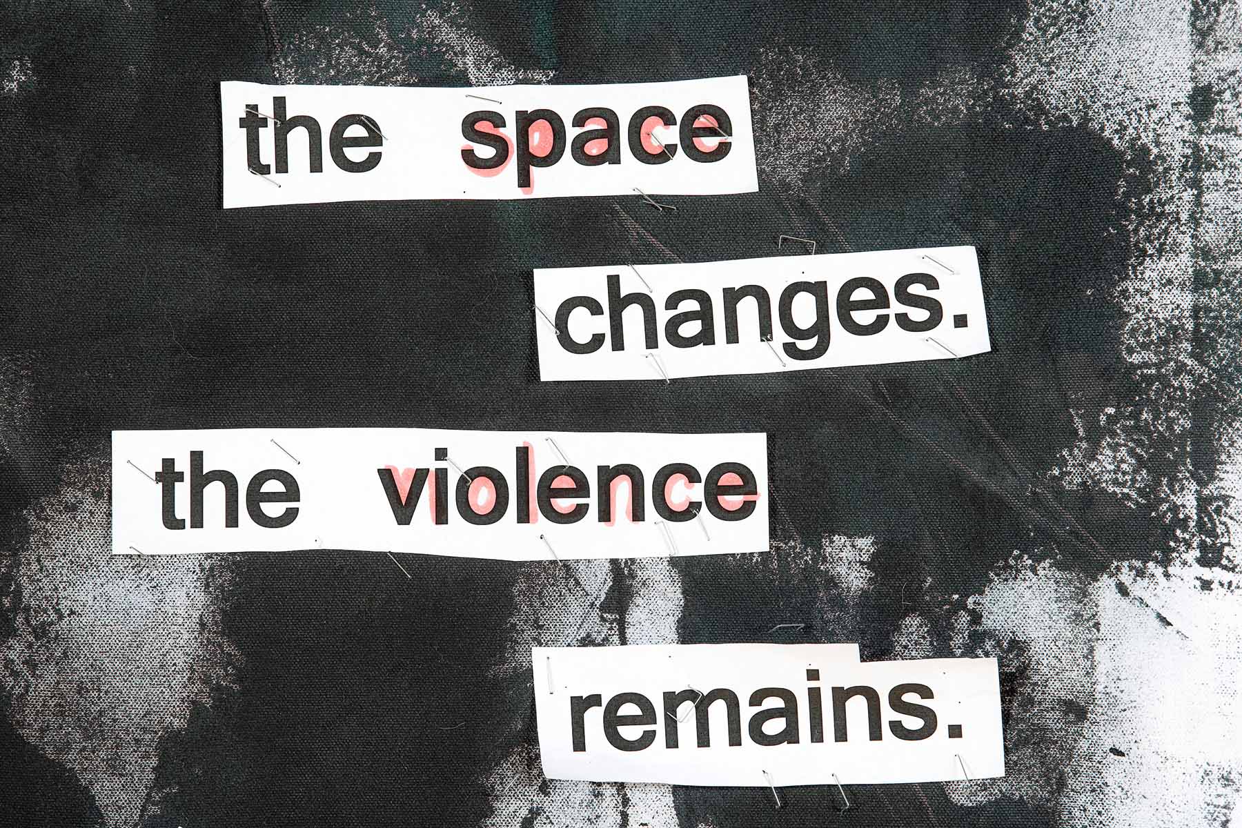 A close-up photograph of the mixed media art piece with word fragments reading, 'the space changes. the vionlence remains.'