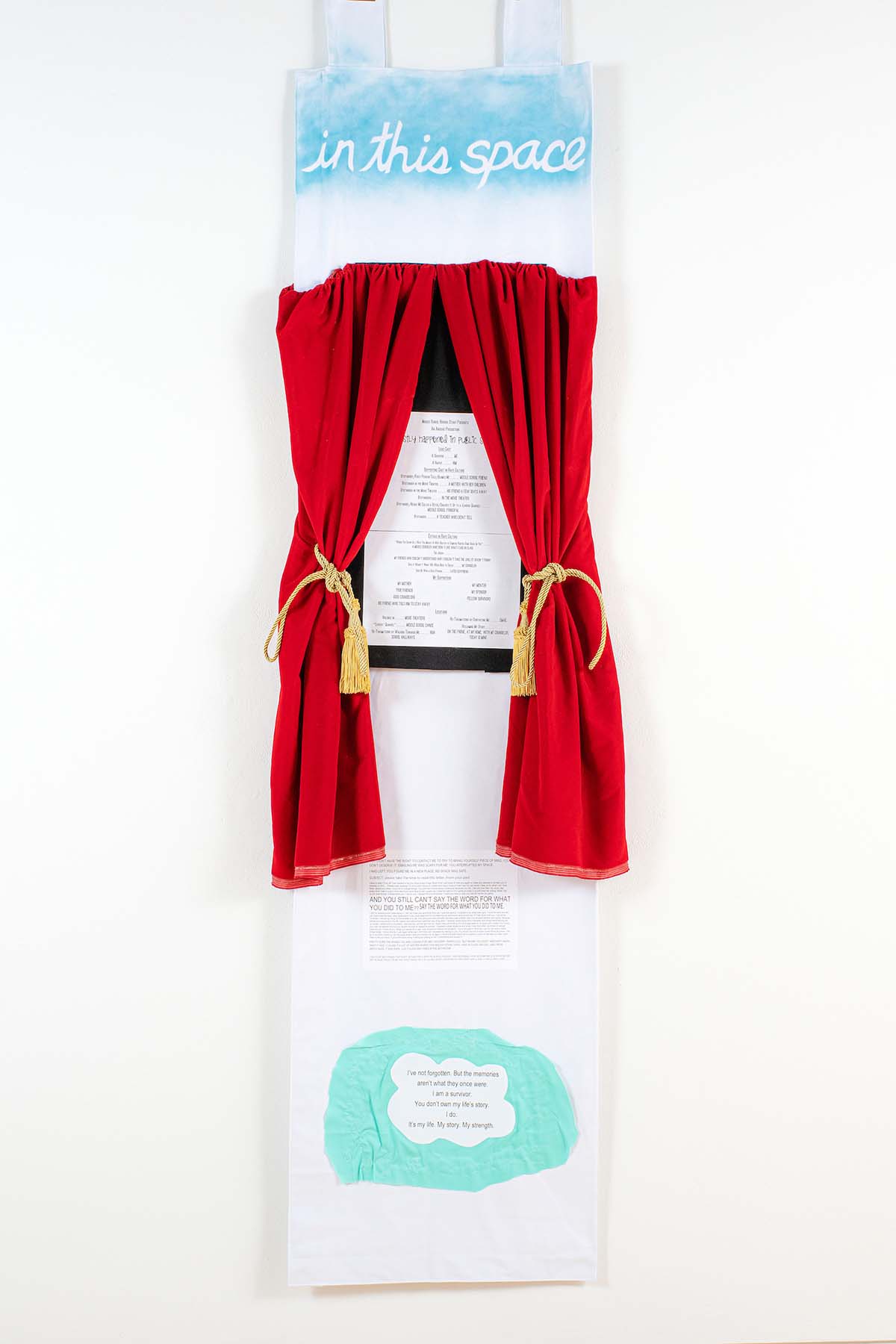 Photo of physical exhibit from the 'In This Space: Disrupted' art gallery depicting a stage with curtains and a credits listing for 'An Abusive Production'