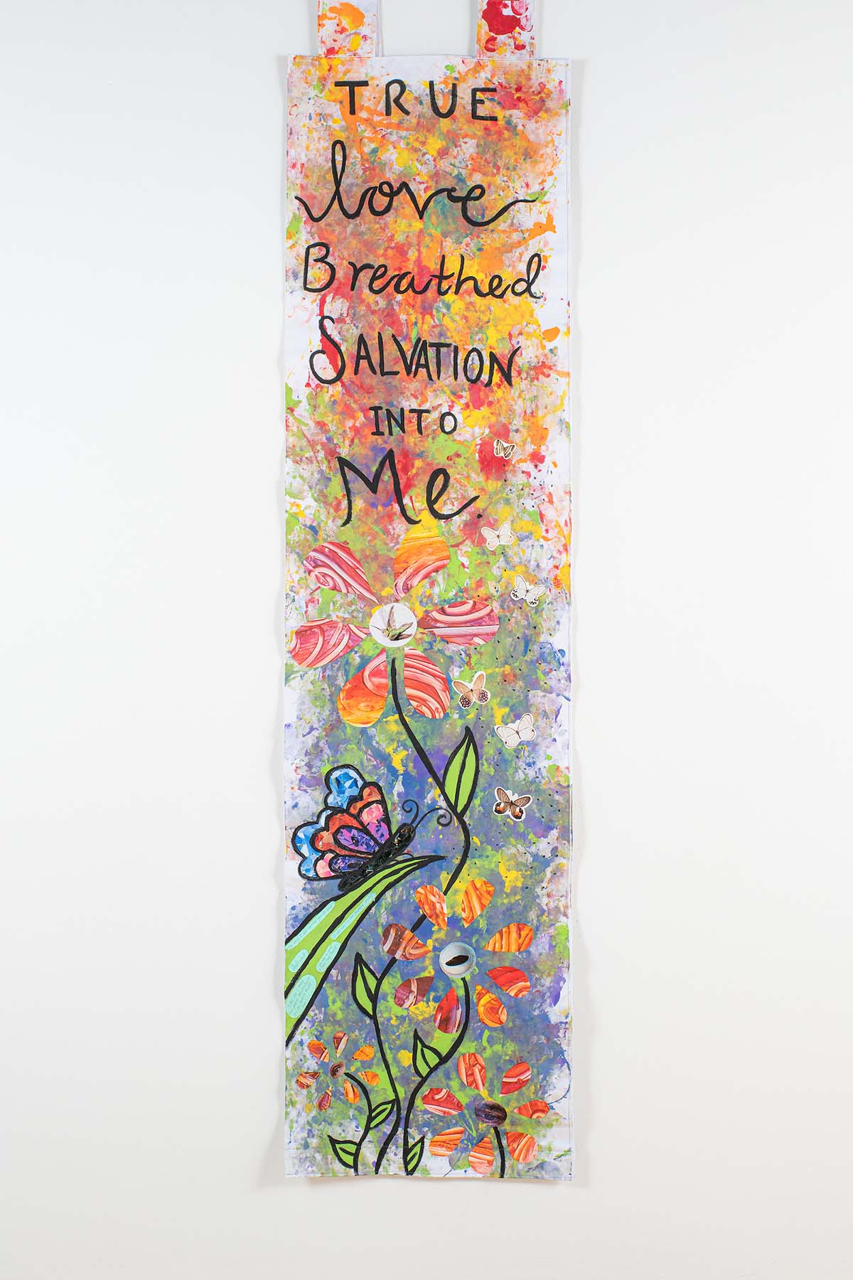 Photo of a colorful mixed media art piece that reads, 'True love Breathed SALVATION INTO Me' above a flower with a butterfly on a blade of grass