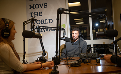 A student talks into the microphone in a podcast studio