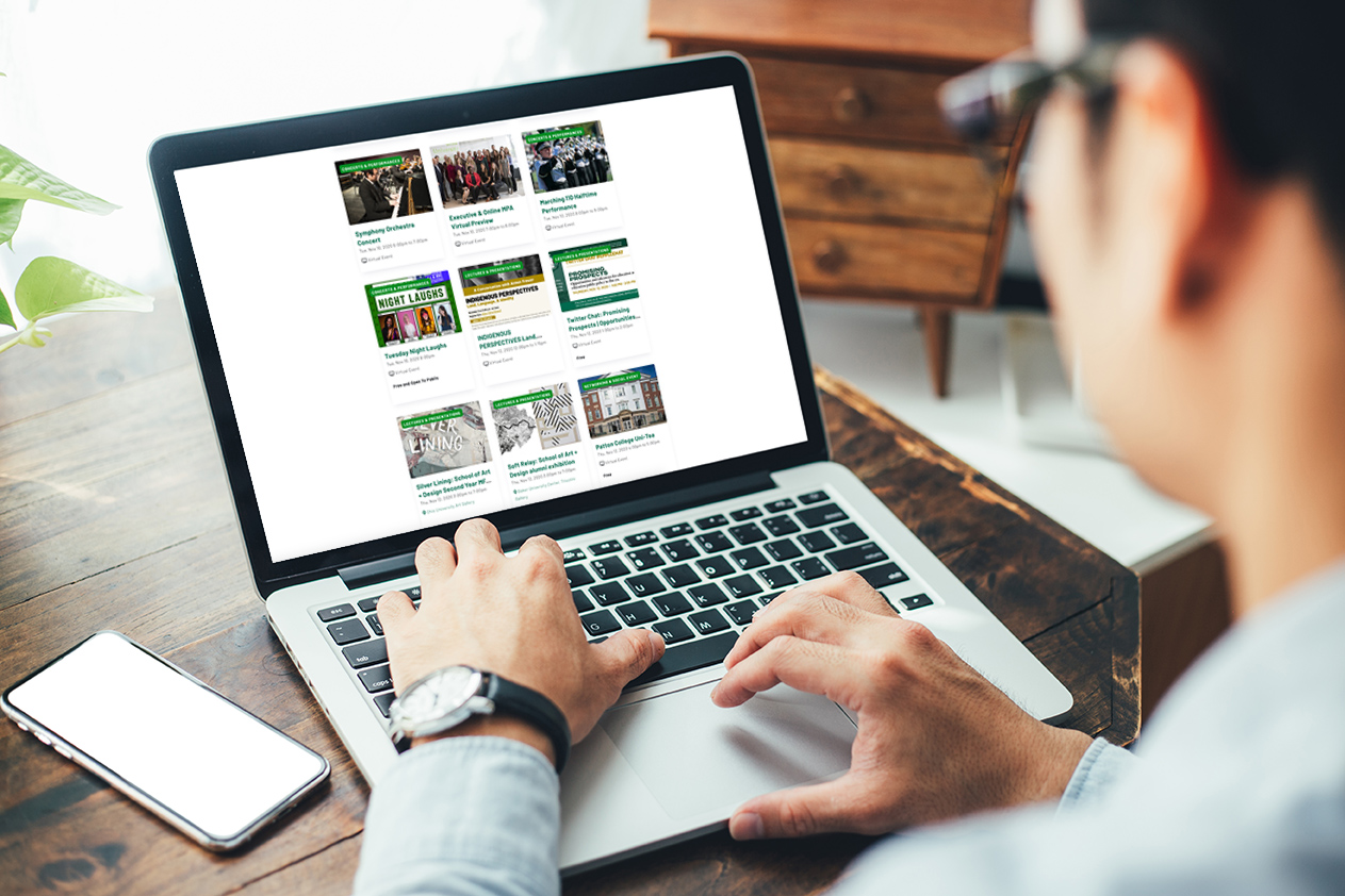 Person browsing Ohio University calendar on a laptop