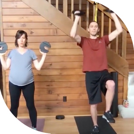 Two people using hand weights in their living room