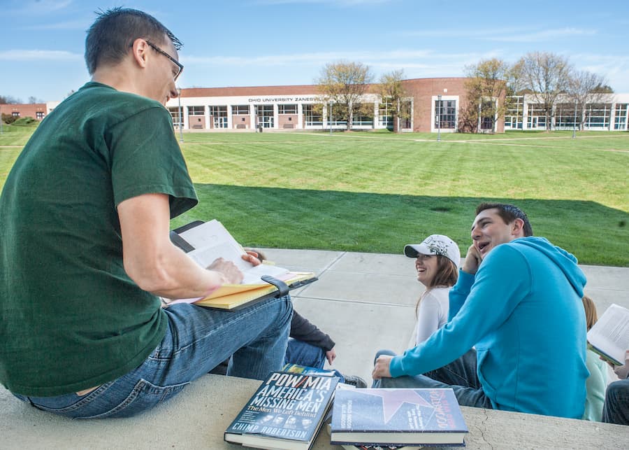 Students study and talk while sitting on the stairs at Ohio University's Zanesville campus.