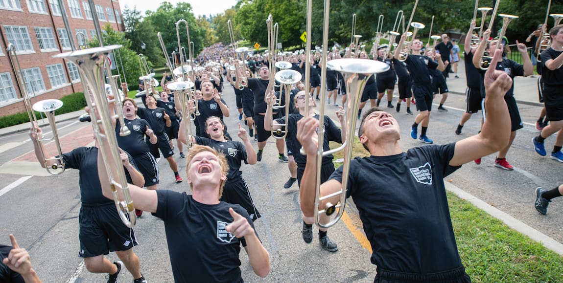 Members of the Ohio University Marching Band shout enthusiastically as they march
