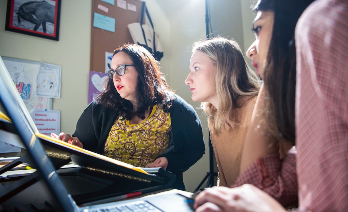 Students gaze intently at a computer screen together