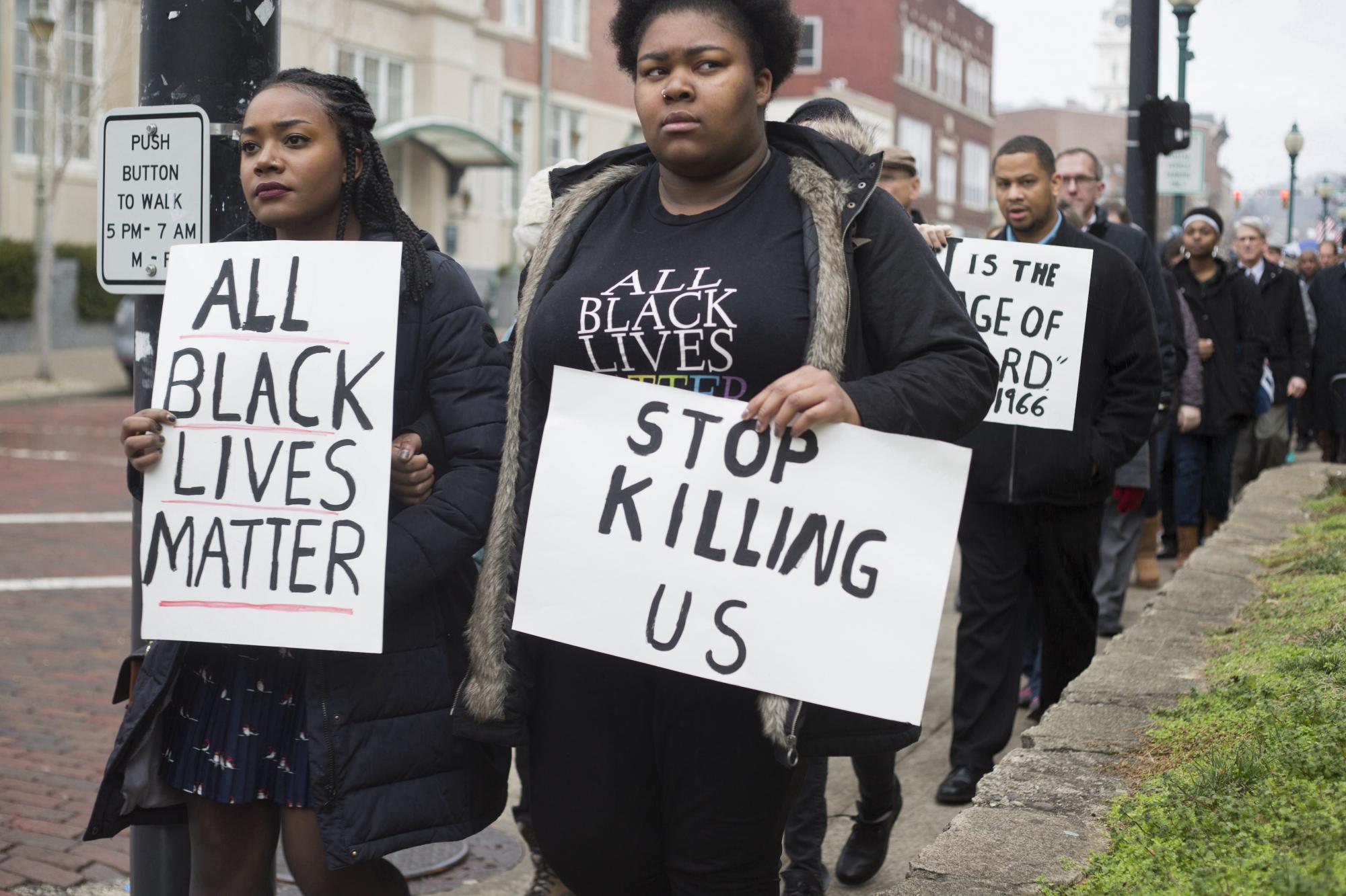 Two Black women holding BLM signs
