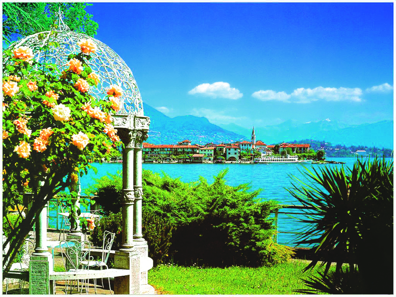 Gazebo and bush with pink flowers on left with Lake Maggiore in the background.