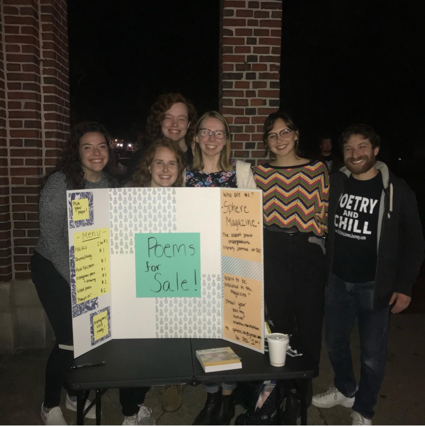 Sphere literary journal students holding up a presentation board