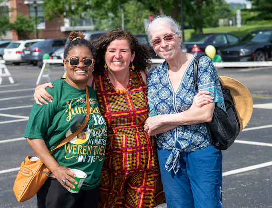 Three Ohio University community members link arms together and smile at the 2021 Juneteenth Celebration in Athens