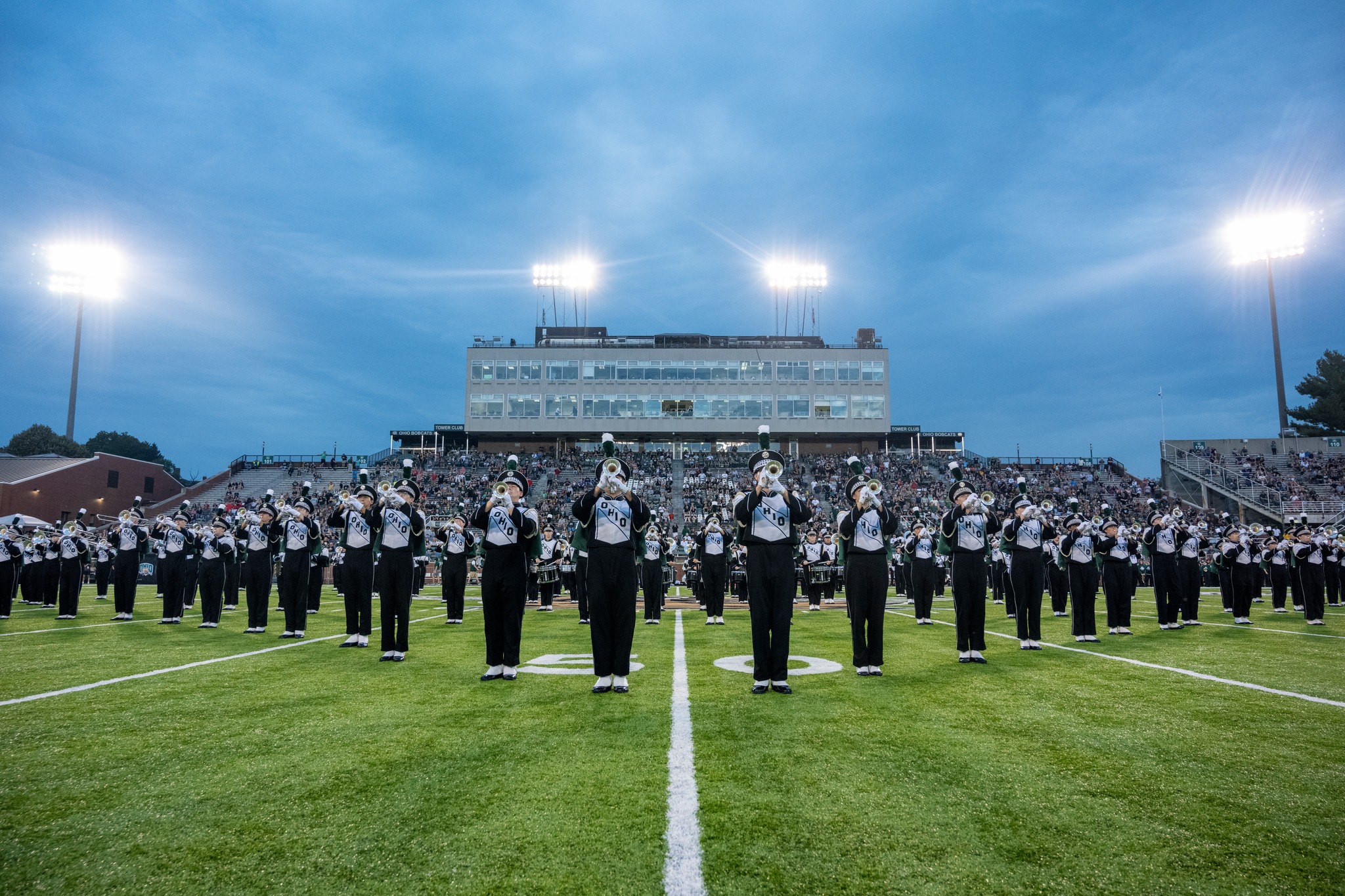 Members of the Ohio University Marching Band play on field during a football game
