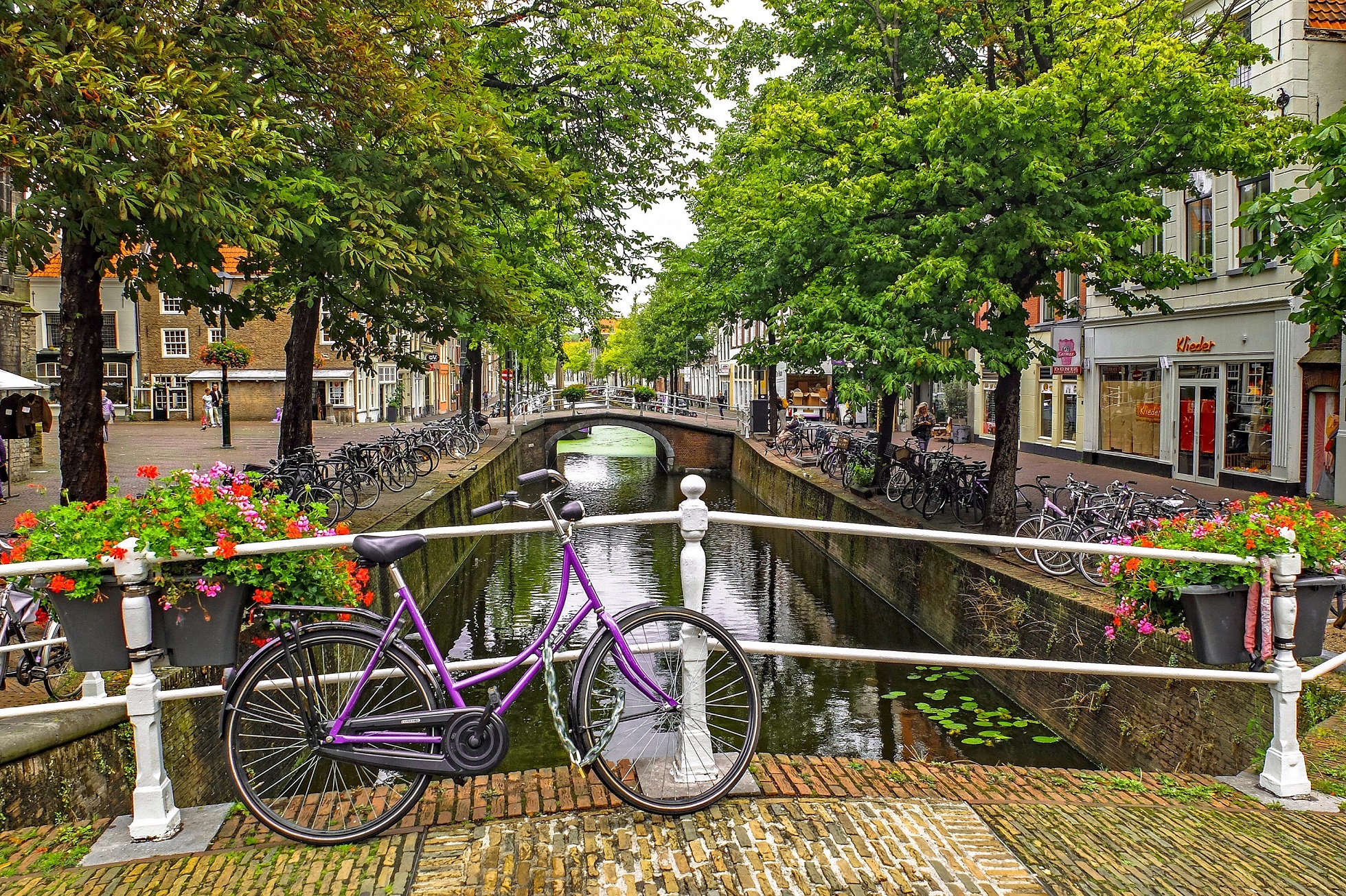 Bike leaning against bridge railing in Amsterdam.
