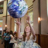 student holding an inflatable earth