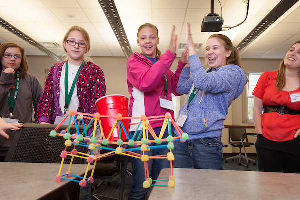 A group of Tech Savvy participants celebrate after building a structure