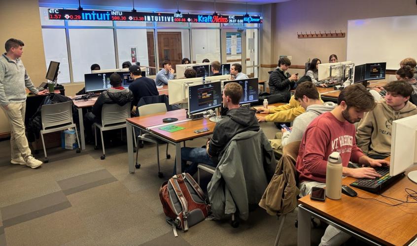 Students work at computers in a finance lab.
