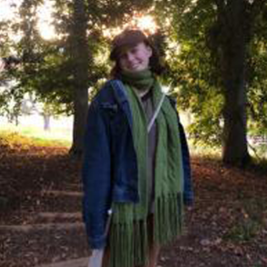 Celia Hawk in a blue sweater with a green scarf in Autumn. 