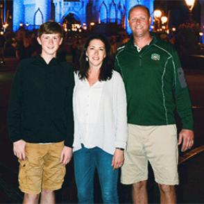 Josh and Jessica Thomas, along with their child, posed in front of Cinderella's Castle at Disney World.