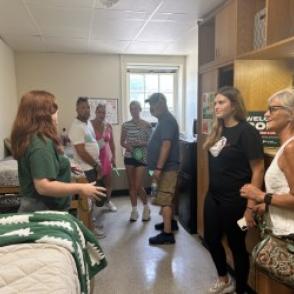students in a room showing a show room to parents and prospective students