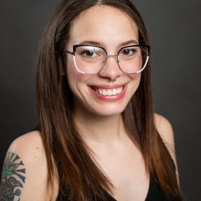 headshot of young woman with glasses in sleeveless shirt