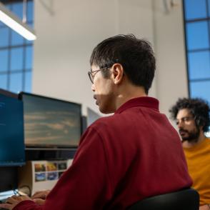 two men working together at a desktop computer