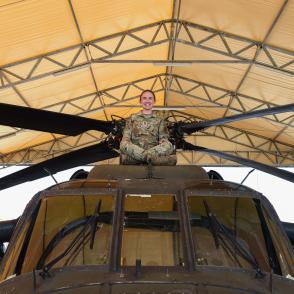 Woman in military uniform sitting atop a helicopter