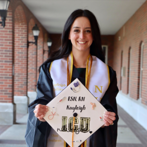 young woman holding graduation cap and smiling