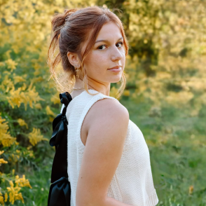 Young woman looking back over her shoulder, yellow flowers in background