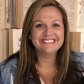 Woman smiling in front of wall of books