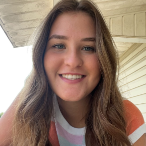 selfie of young woman sitting outside and smiling