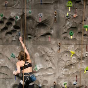 woman climbing wall at ping center