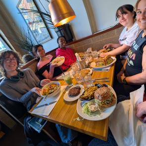 Participants smile at the camera with their plates of food