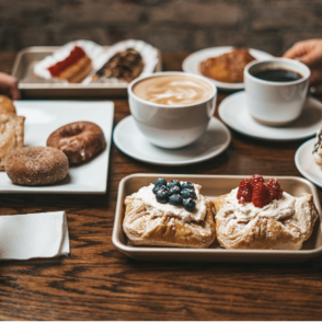 Coffee and pastries on wooden table.