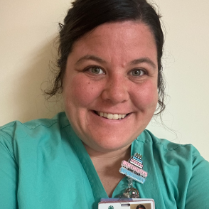 Portrait of graduate Brittany Sansom smiling and wearing scrubs
