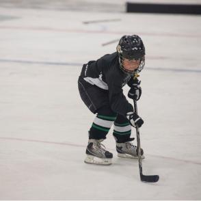 kid learning to play hockey in community program