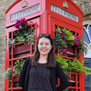 A woman in front of a London style public telephone box