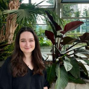 A photo of a woman in front of plants