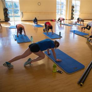 students take the mountain climber pose on their mats in the cardio sculpt class