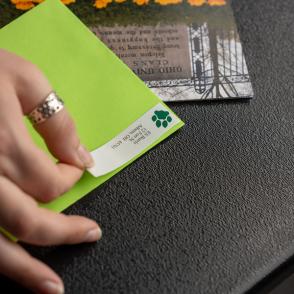 student from marketing team sticks labels to mail
